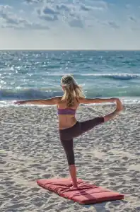 Woman does yoga on a beach
